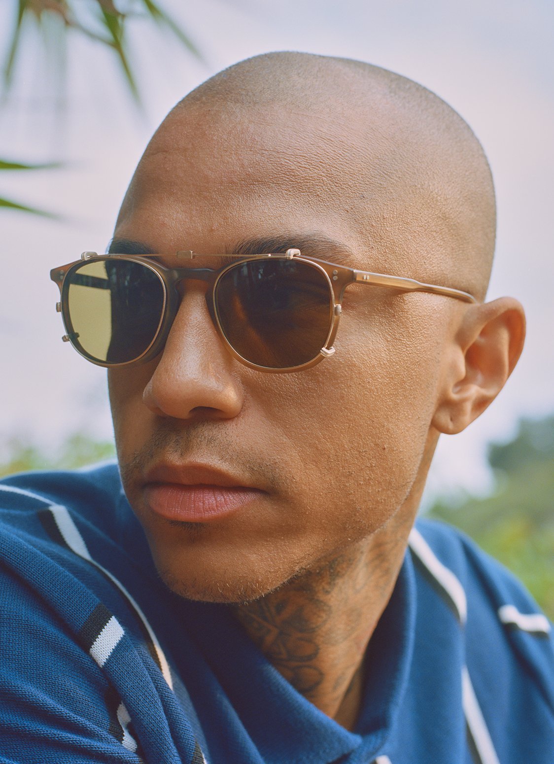 Model wears a folding sunglass clip in Gold created for the Garrett Leight California Optical Kinney eyeglass, available in two sizes and multiple colorways.