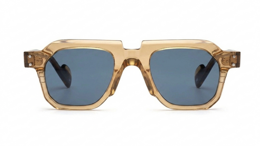 A pair of oversized square sunglasses with a translucent gold acetate frame and muted blue-gray lenses, shown against a plain white background.