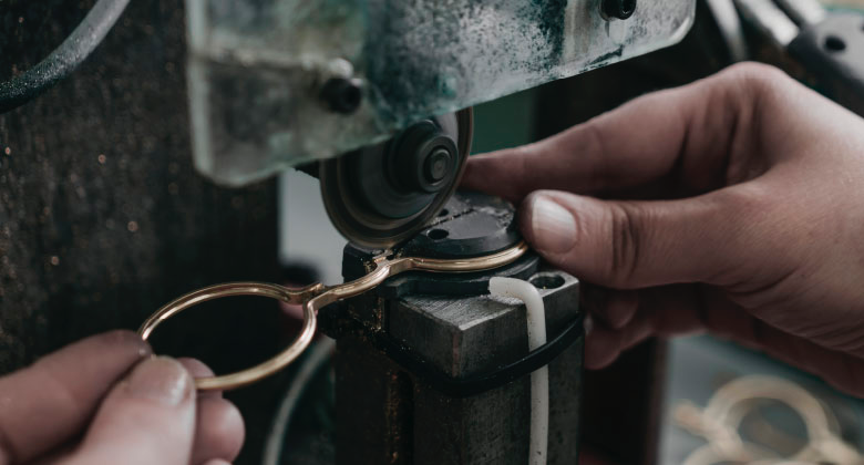 Person adjusting a pair of eyeglasses with a focus on the mechanism.